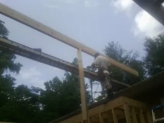 Carpenter setting a ridge beam over a new addition frame — Ice Dam Removal by Roofing Brothers in Lake Katrine