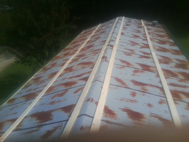 Rusted metal roof panels with new wood purlins before replacement — Storm Damage Roof Repair in Lake Katrine by Roofing Brothers
