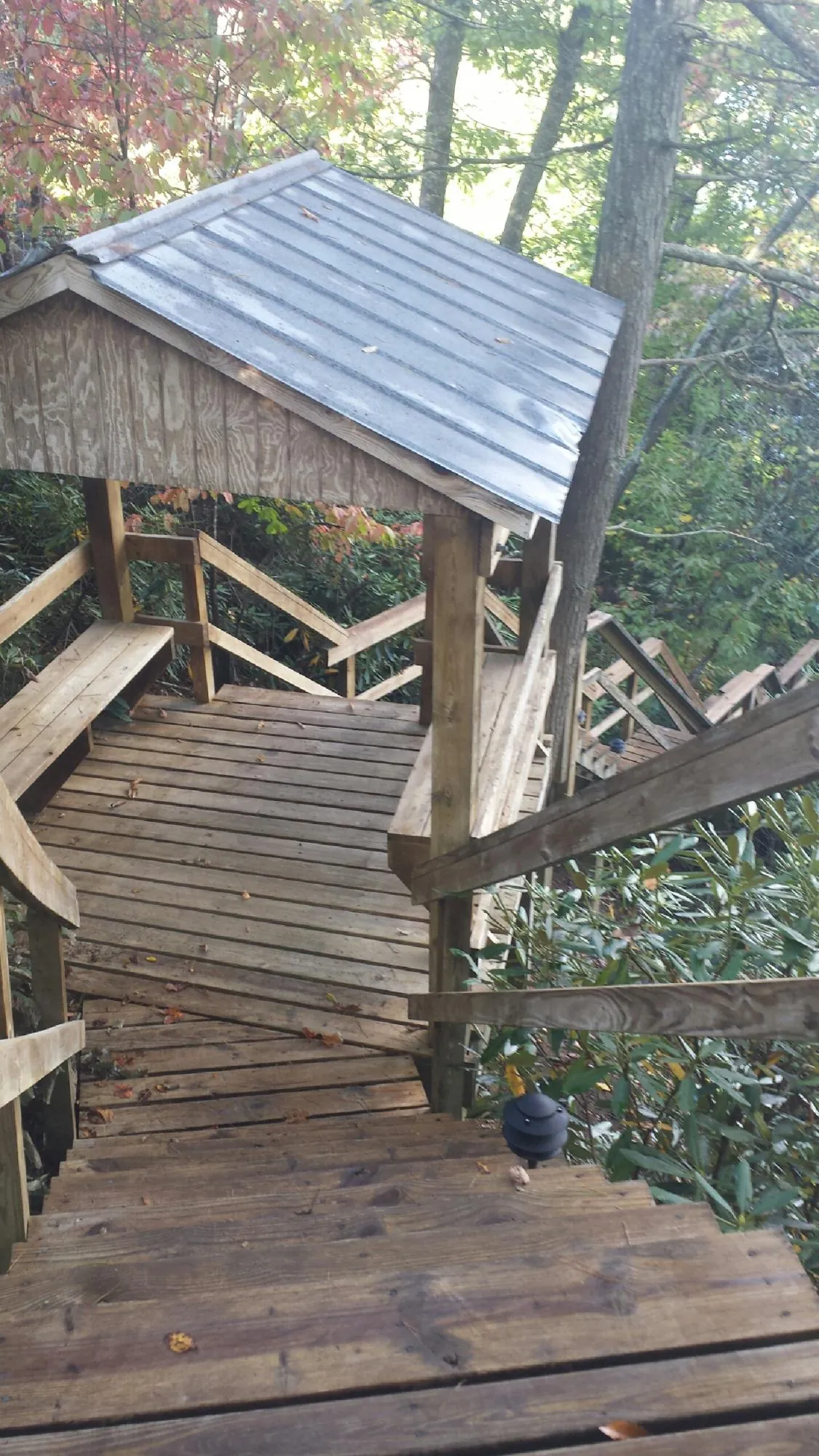 Metal roofed shelter over wooden steps on a wooded walkway — Skylight Repair & Installation work by our crew in Lake Katrine