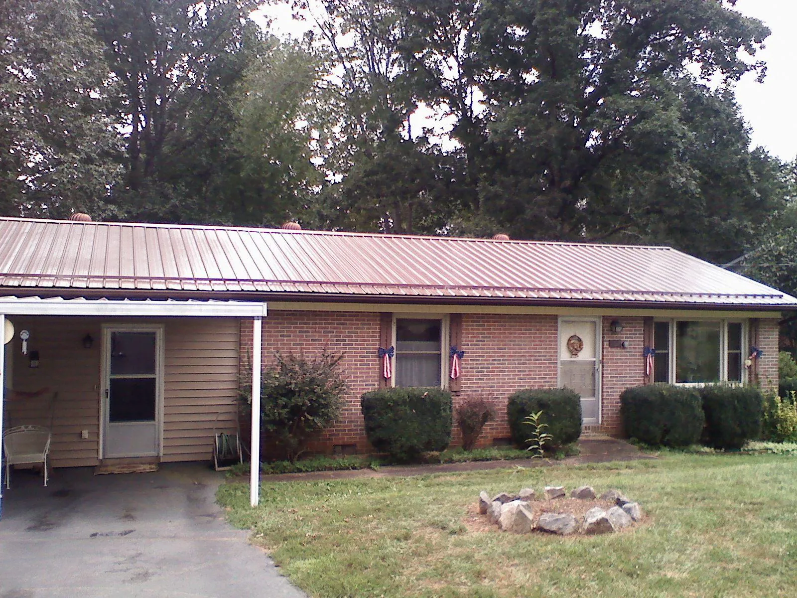 Bronze metal roof and carport on a brick ranch home — Roof Repair work by our crew in Lake Katrine